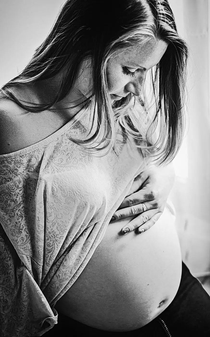 pregnant mum showing her belly on a pregnancy photo shoot with Emerald Photo UK at home